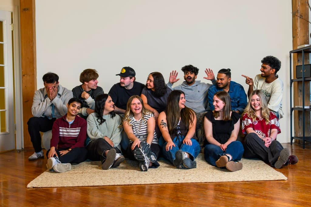 A joyful group of young people laughing together in a warm, welcoming space